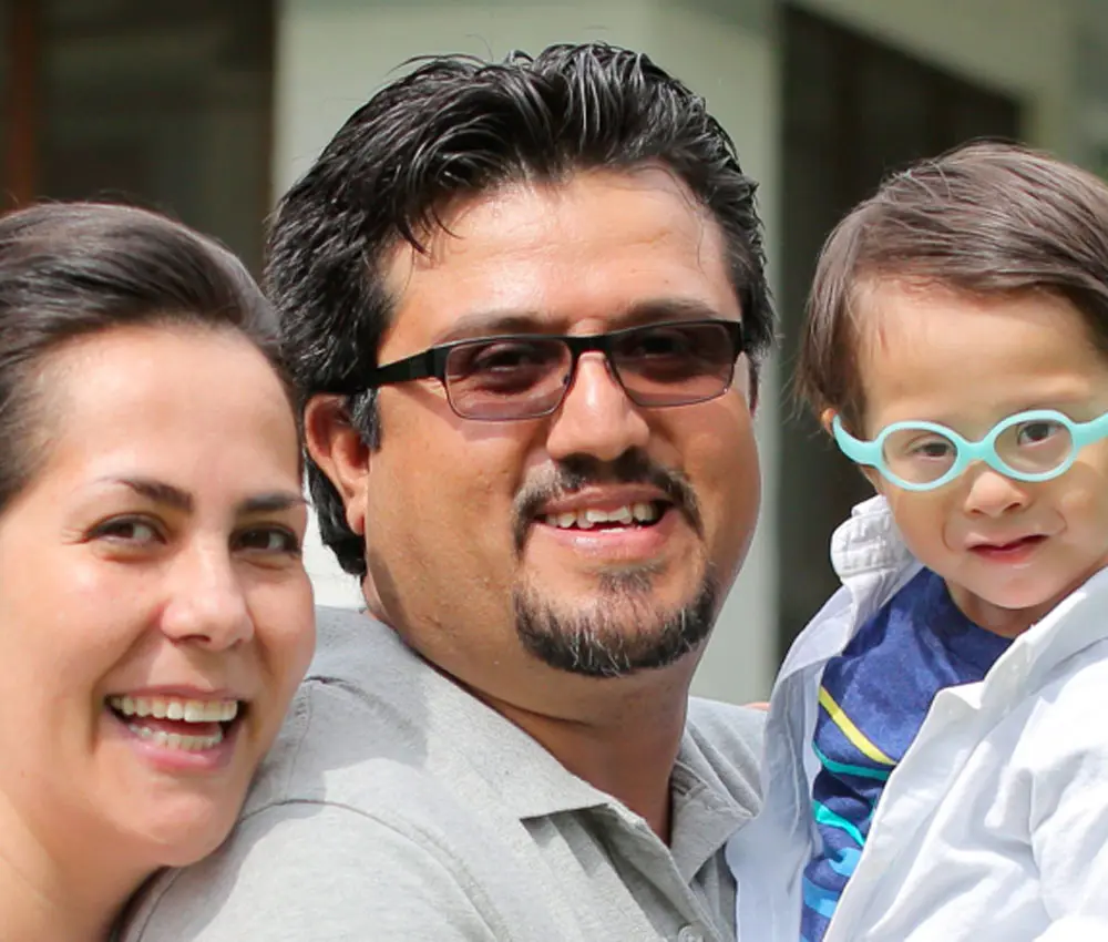 A couple smiling with their child.